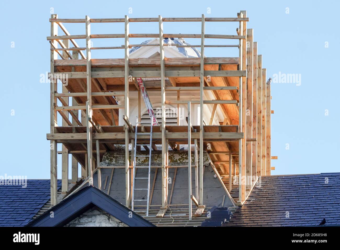 Holzgerüst um eine Struktur auf einem gefliesten Dach Stockfoto