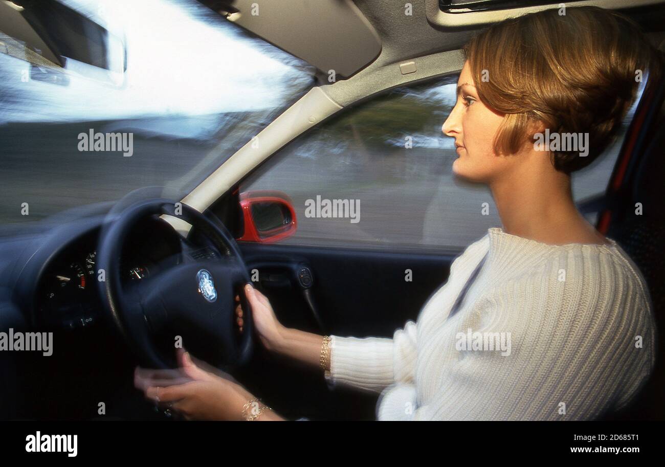 Junge Frau fährt einen Vauxhall Corsa Stockfoto