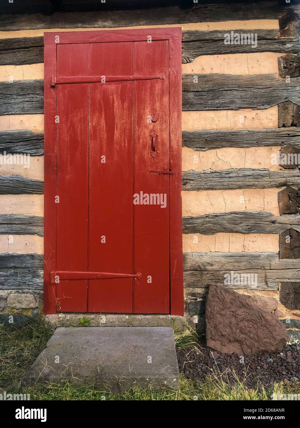 Rote Tür in einer kolonialen Pennsylvania Blockhütte. Stockfoto