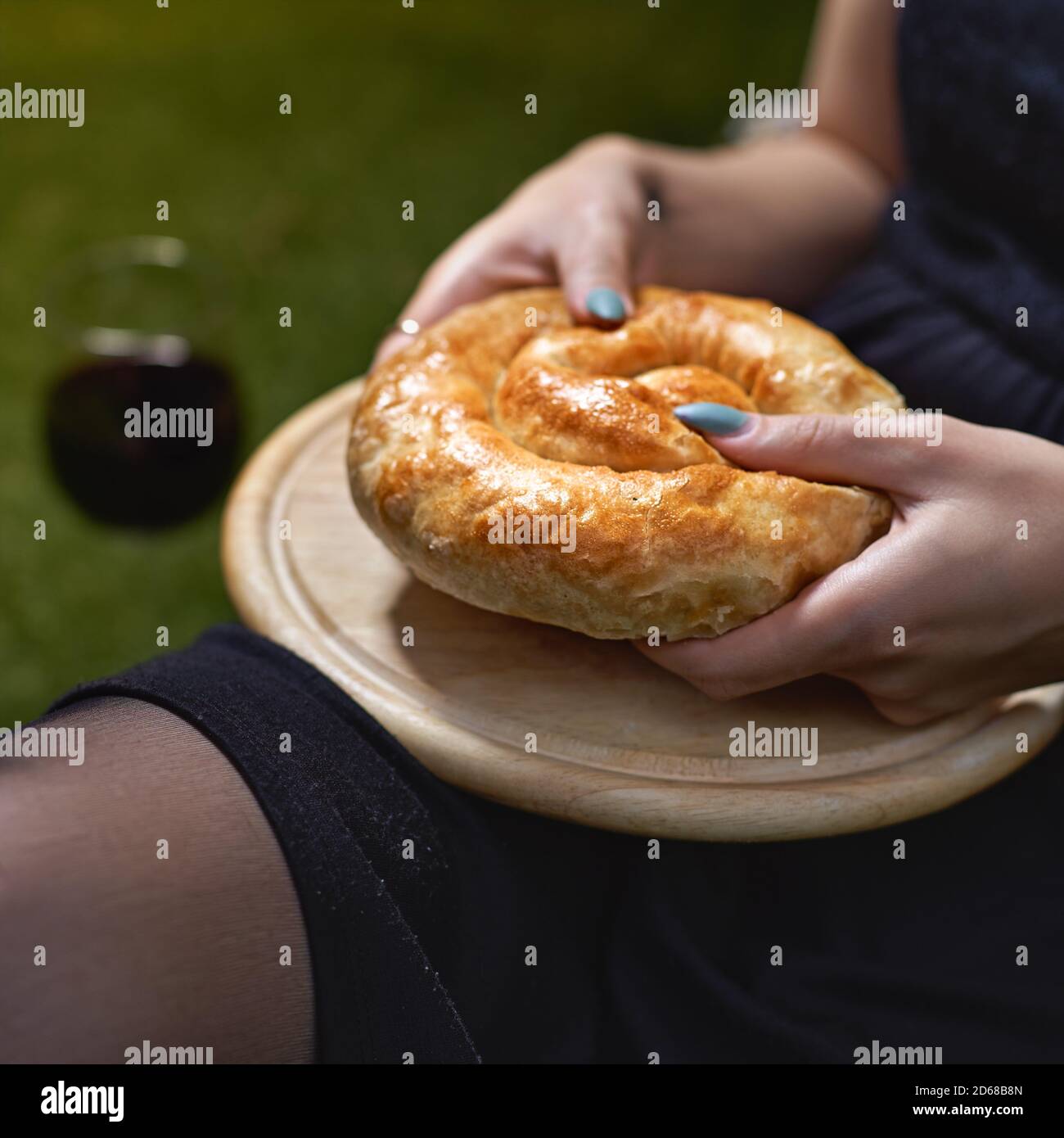 Kuchen mit Gemüse in den Händen einer Frau auf einem Tablett. Gemütliche authentische Atmosphäre. Stockfoto