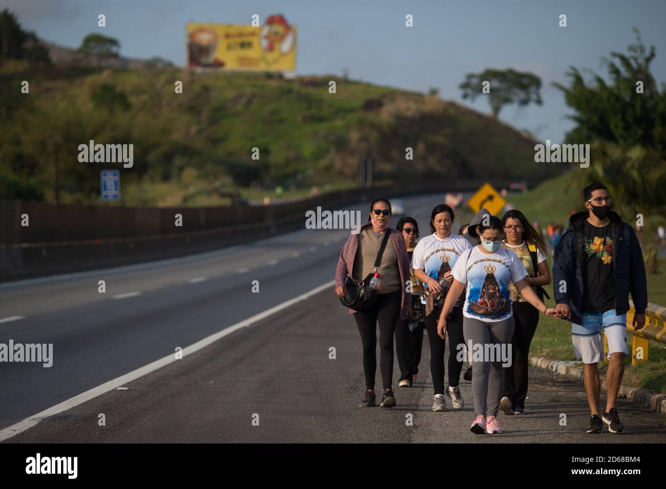 Aparecida, Brasilien. Oktober 2020. Pilger wandern entlang einer Autobahn zur Basilika von Nossa Senhora Aparecida, während des Tages von Nossa Senhora Aparecida, der schutzpatronin Brasiliens. Zum ersten Mal in der Geschichte der Basilika mussten wegen der Corona-Pandemie die Messen hinter verschlossenen Türen oder in Anwesenheit einer kleinen Anzahl von Menschen gefeiert werden. Quelle: Fernando Souza/dpa/Alamy Live News Stockfoto