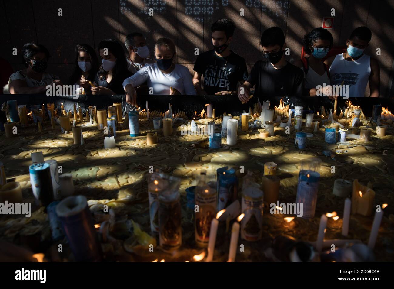 12. Oktober 2020, Brasilien, Aparecida: Gläubige zünden ihre Kerzen an und beten im Kerzenraum der Basilika von Nossa Senhora Aparecida, am Tag von Nossa Senhora Aparecida, der schutzpatronin Brasiliens. Zum ersten Mal in der Geschichte der Basilika mussten wegen der Corona-Pandemie die Messen hinter verschlossenen Türen oder in Anwesenheit einer kleinen Anzahl von Menschen gefeiert werden. Foto: Fernando Souza/dpa Stockfoto