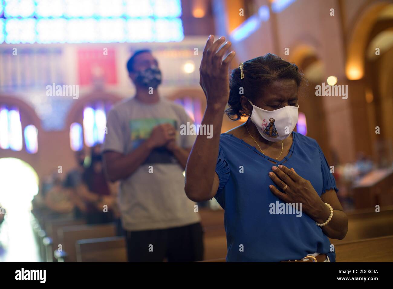 12. Oktober 2020, Brasilien, Aparecida: Gläubige mit Mund- und Nasenschutz beten während der Hauptmesse in der Basilika Nossa Senhora Aparecida, der schutzpatronin Brasiliens, um den Tag der Nossa Senhora Aparecida zu feiern. Zum ersten Mal in der Geschichte der Basilika mussten wegen der Corona-Pandemie die Messen hinter verschlossenen Türen oder in Anwesenheit einer kleinen Anzahl von Menschen gefeiert werden. Foto: Fernando Souza/dpa Stockfoto