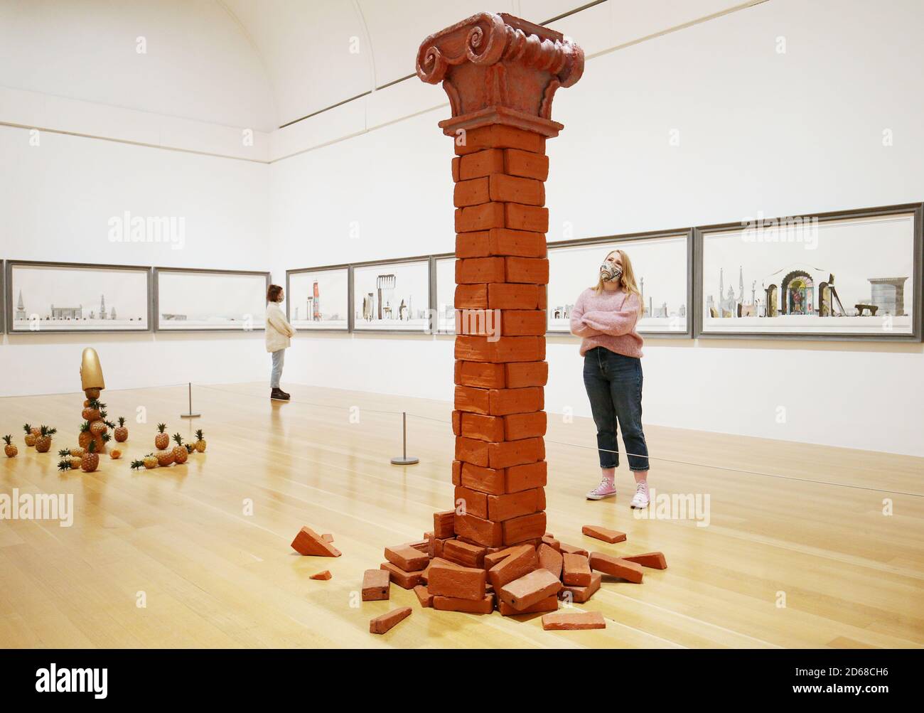 Tate-Mitarbeiter stehen vor verschiedenen Arbeiten von Pablo Bronstein und Edward Allington während einer Fotoausstellung für die neuen Sammlungsausstellungen in der Tate Britain in London. Stockfoto