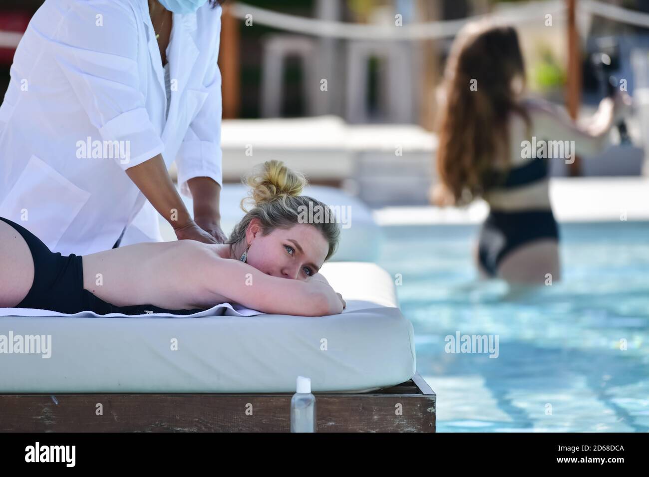 Nahaufnahme einer blonden Frau, die den Bauch nach unten legt und eine Massage mit einer unfokussieren Frau auf dem Rücken erhält. Freizeit- und Wohlbefindungs-Konzept. Stockfoto