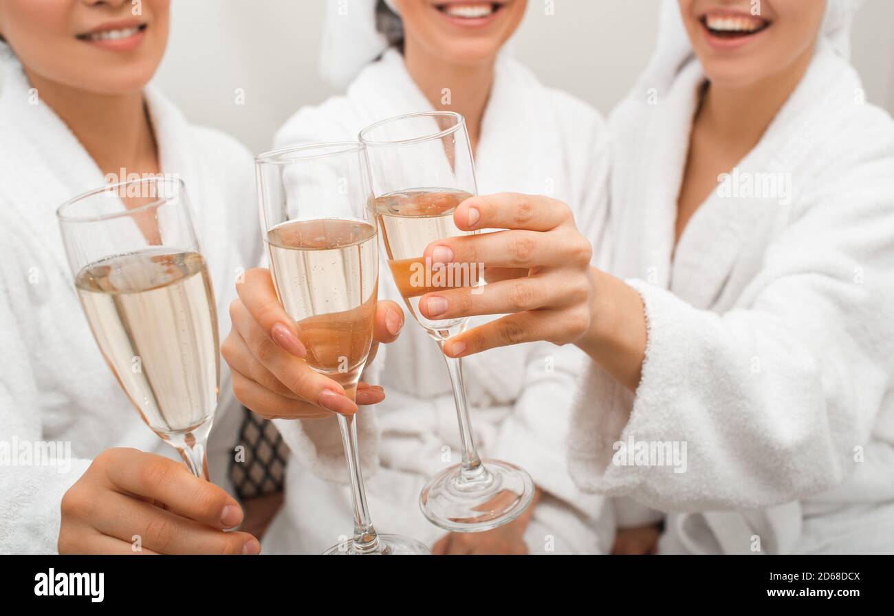 Klirrrrende Gläser mit Champagner. Nahaufnahme von Getränken in den Händen von Frauen, die sich in einem Spa entspannen Stockfoto