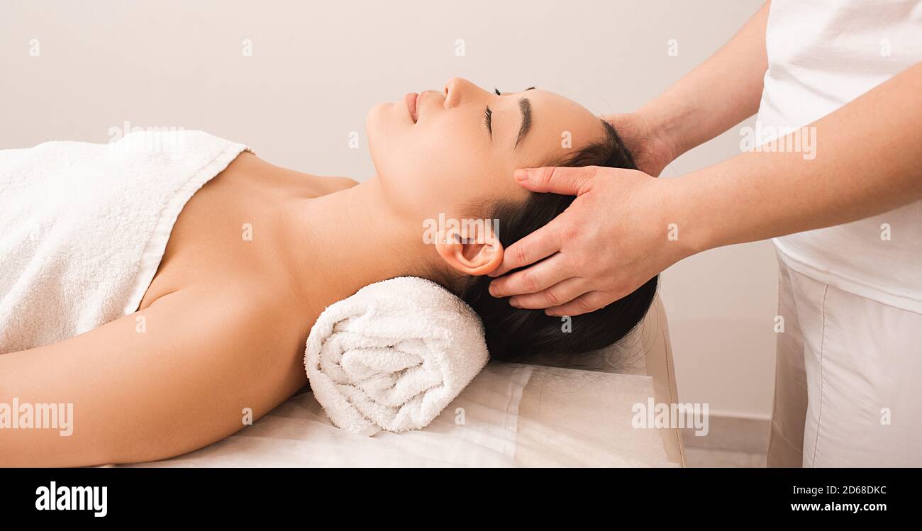 Entspannende Kopfmassage gegen Stress. Schöne Frau entspannt in einem Massagesalon während einer Massage Stockfoto