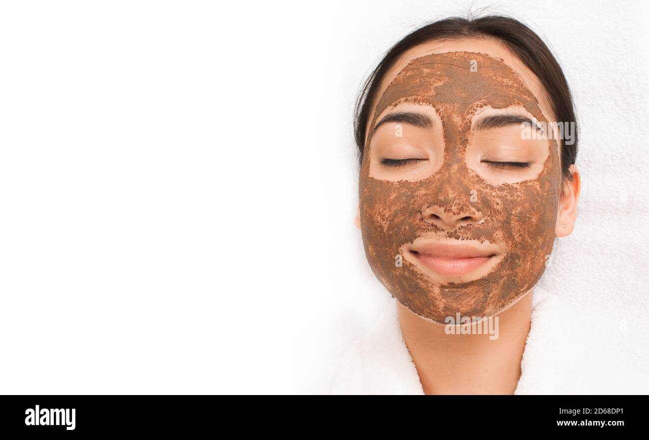 Frau mit einer Schlammmaske im Gesicht. Behandlung, Reinigung und Erweichung der Haut. Teil einer Serie mit Schlammmaske Stockfoto
