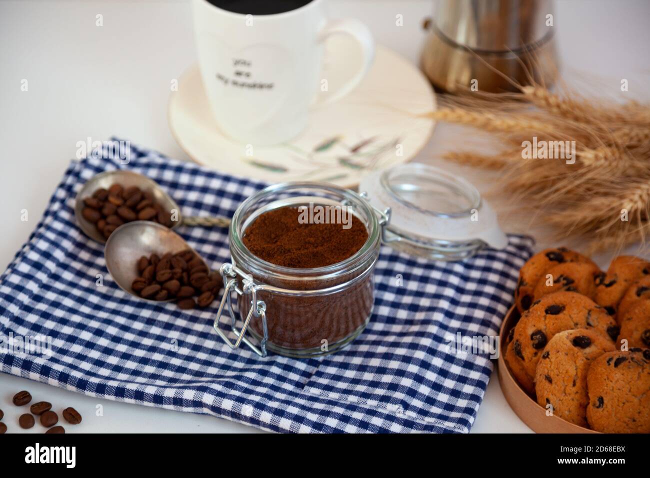Kaffeebohne, ood Hintergrund. Stillleben mit Cookies. Frühstück, Blick von oben. Kaffeekörner aus einer Dose auf Küchentisch gegossen. Kaffeetasse Stimmung. Stockfoto