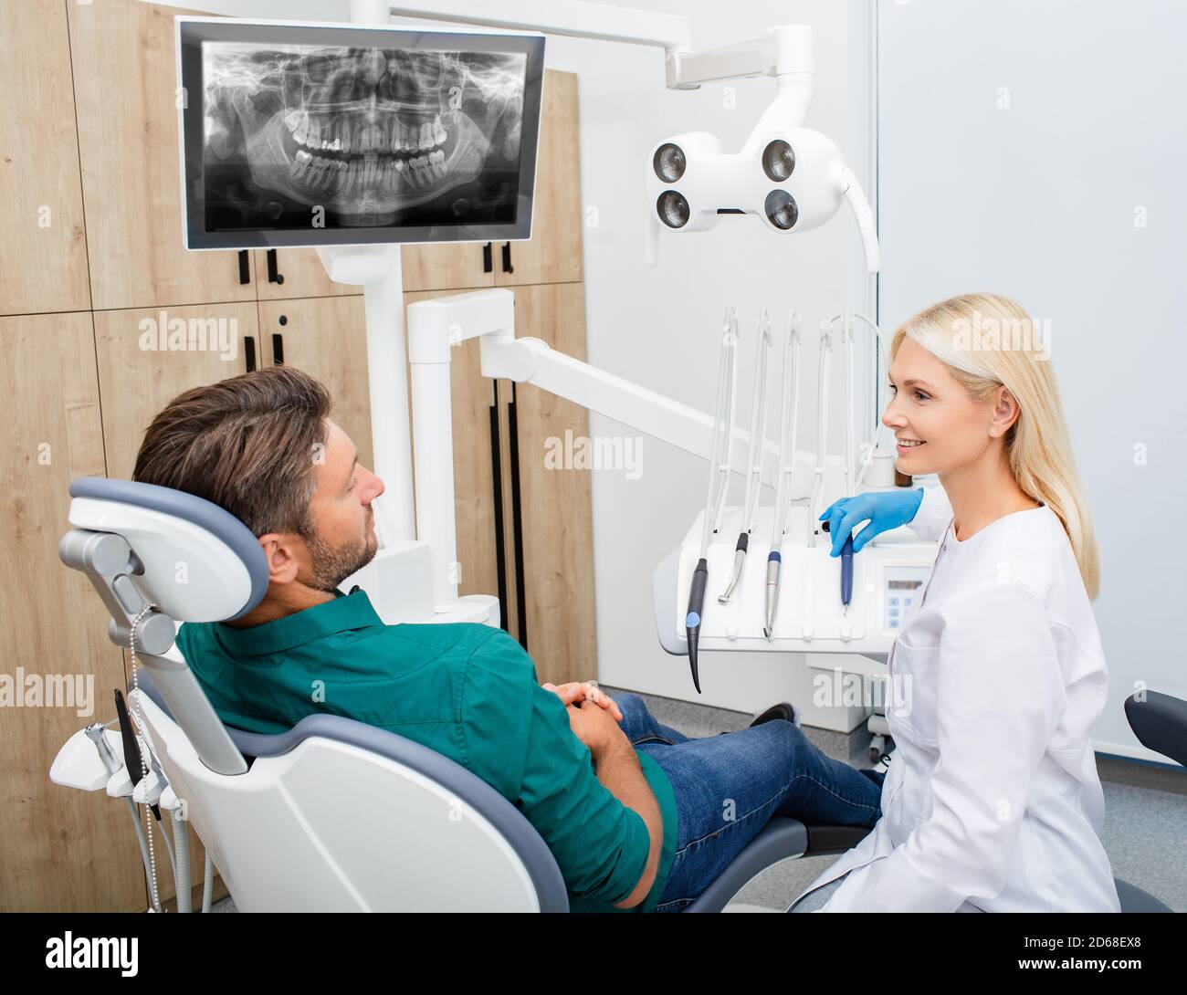 Schöne Frau Zahnarzt Beratung eines Mannes Patienten in der Zahnarztpraxis. Stomatologie und Gesundheitskonzept Stockfoto