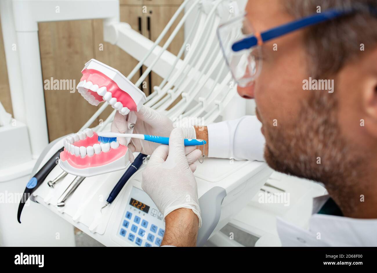 Erfahrener Zahnarzt, der Zähne auf anatomischen Zähnen richtig putzt Modell Stockfoto