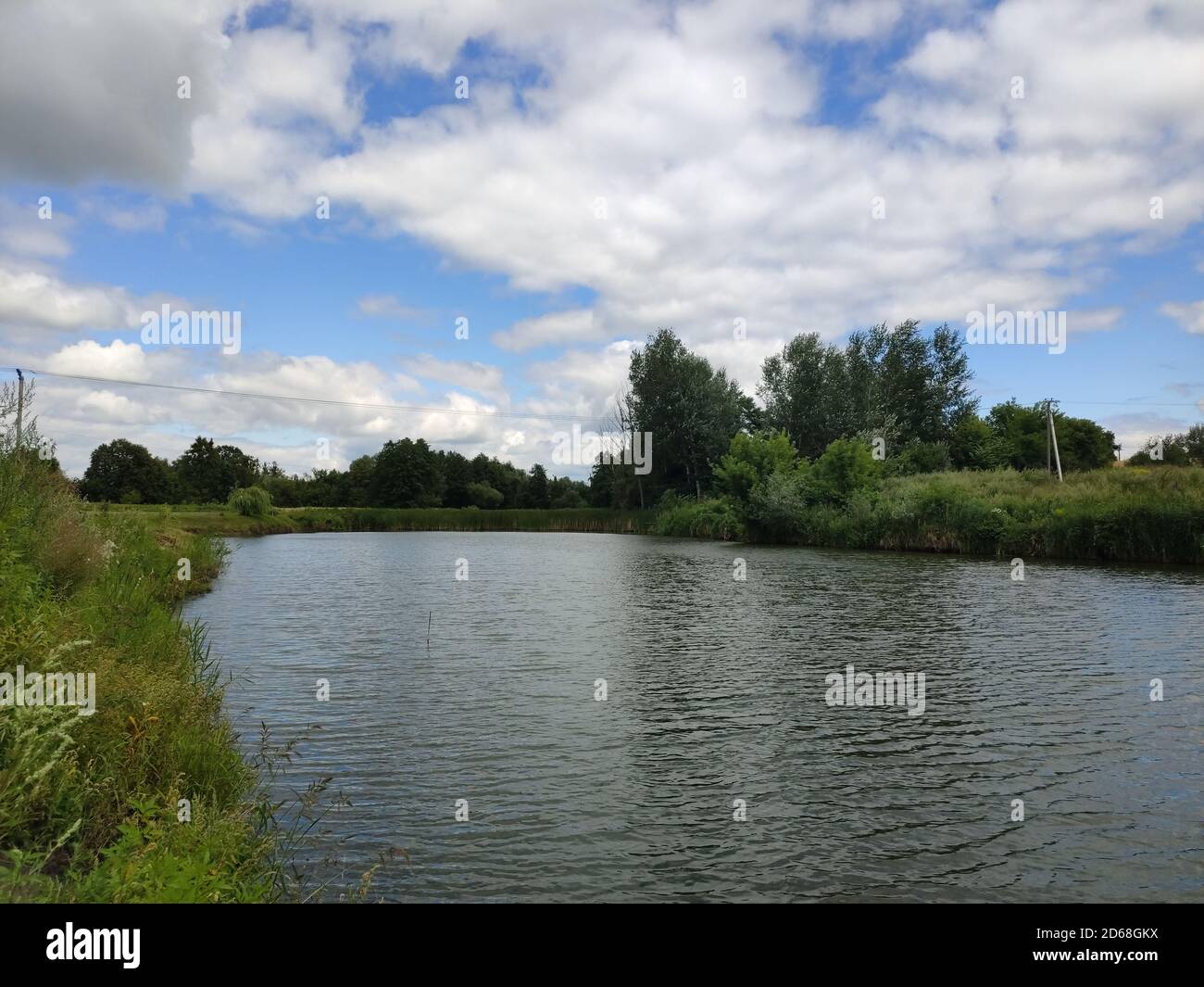 Ein großes Flussbett mit Gras und Bäumen im Sommer Stockfoto