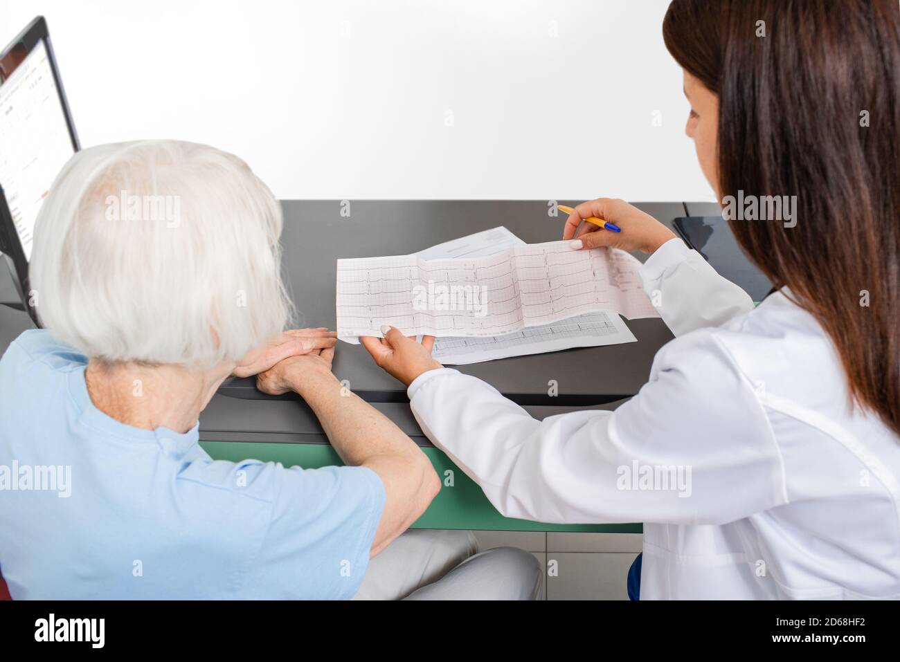 Der Kardiologe befragt eine ältere Frau zu den Ergebnissen eines Elektrokardiogramms. Herzinfarkt, Testergebnisse Stockfoto