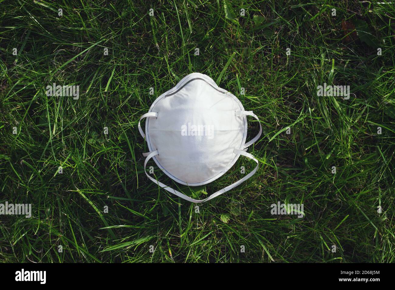 Medizinische Schutzmaske auf dem Gras. Konzept Der Luftverschmutzung, Lungenentzündung Ausbrüche, Coronavirus Epidemien, Und Das Risiko Der Biologischen Kontamination Stockfoto