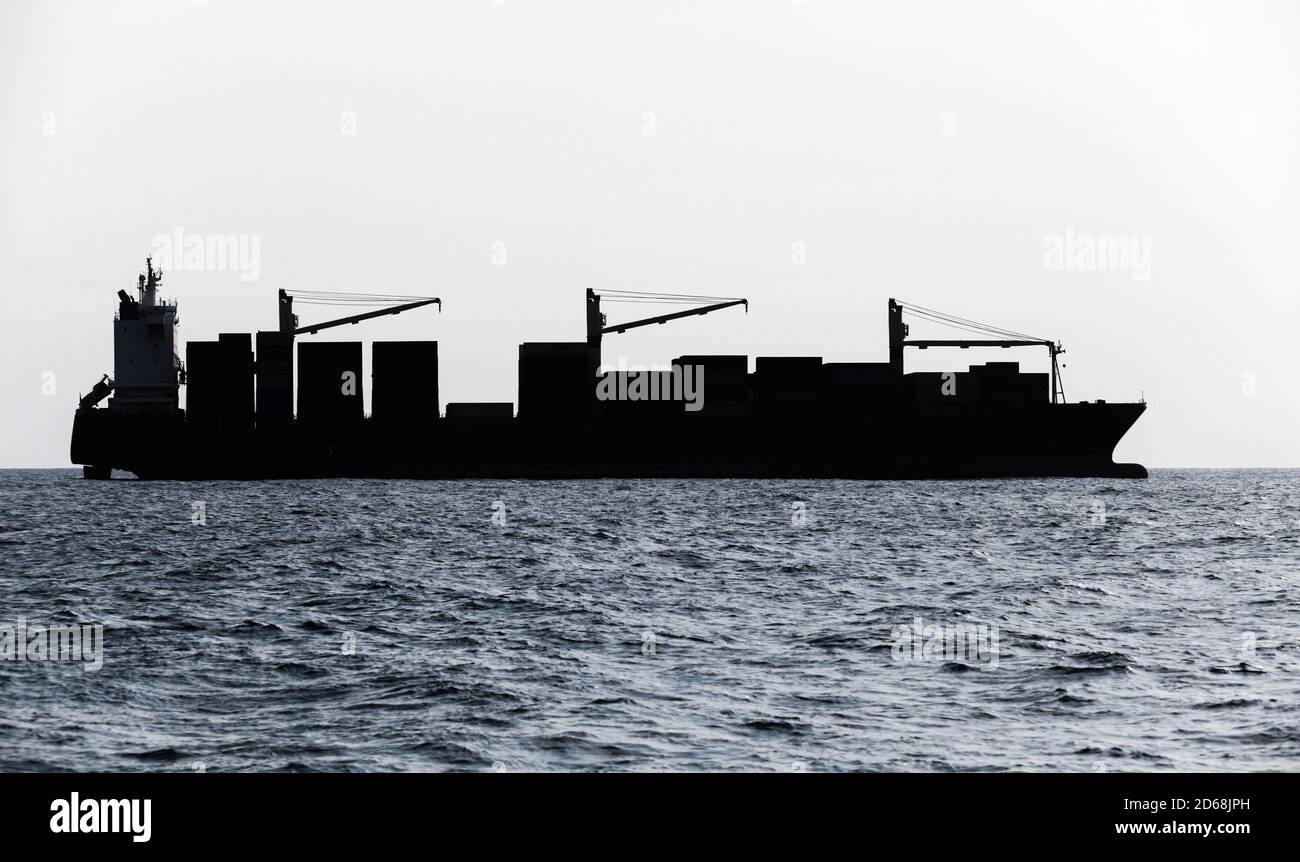 Containerschiff geht auf See. Blau getönte Silhouette Foto Stockfoto