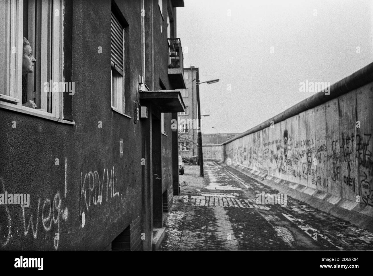 Eine ältere Dame schaut über die Mauer (West-Berlin) Stockfoto