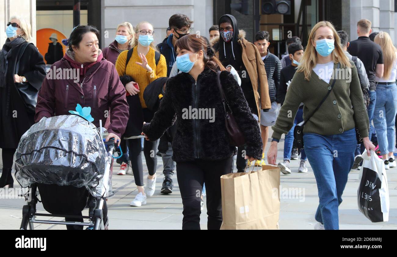 Besucher mit Gesichtsmasken gehen entlang der Regent Street.Öffentliche Menschen werden beim Einkaufen in London mit Gesichtsmasken gesehen.nach der Ankündigung des Premierministers Boris Johnson, ein neues dreistufiges Schließsystem aufgrund der zunehmenden Fälle von Coronavirus-Infektionen in Großbritannien zu installieren. Stockfoto
