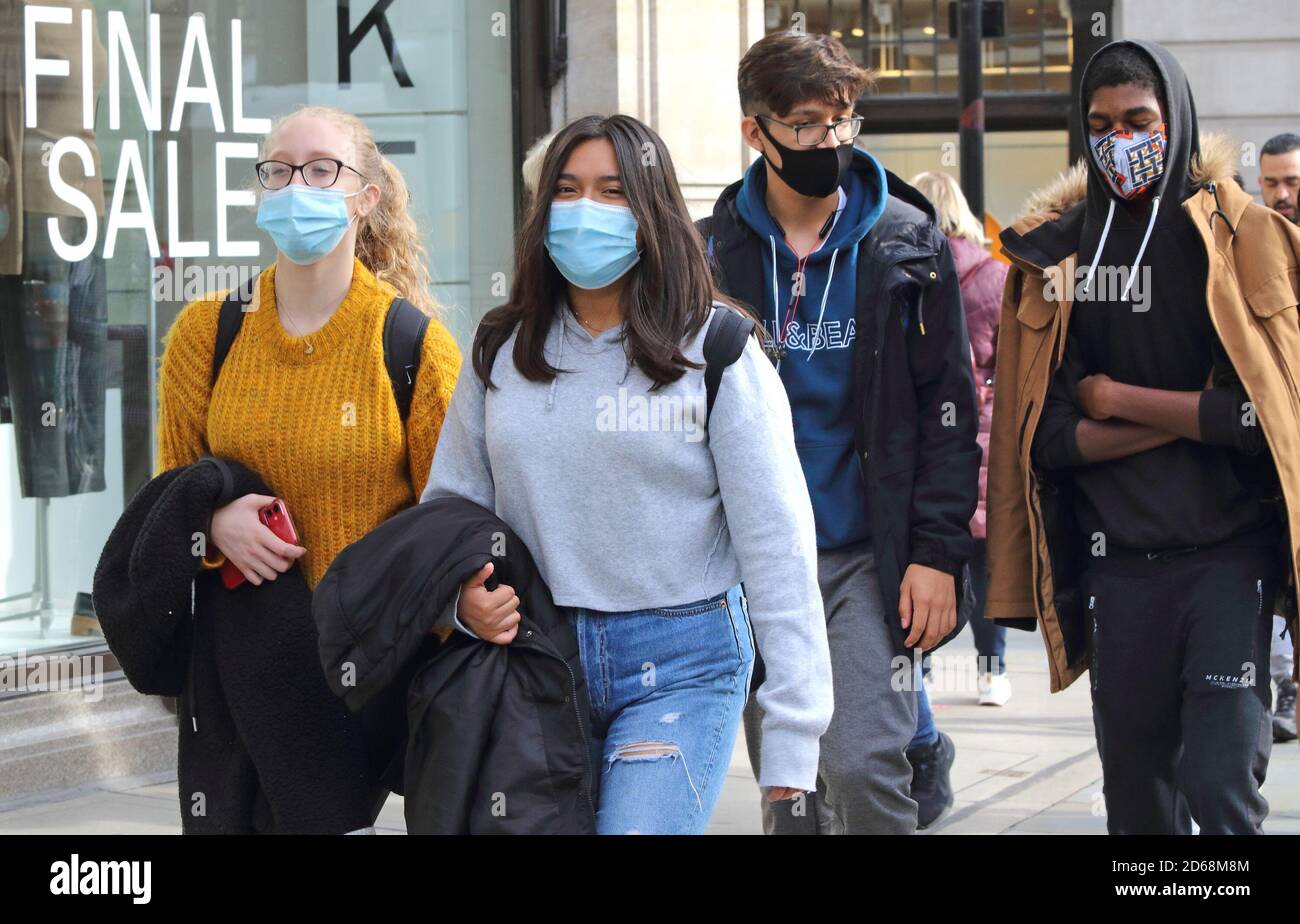 Käufer mit Gesichtsmasken gehen entlang der Regent Street Öffentliche Menschen werden beim Einkaufen in London mit Gesichtsmasken gesehen, nachdem Premierminister Boris Johnsons Ankündigung eines neuen dreistufigen Sperrsystems wegen der zunehmenden Fälle von Coronavirus-Infektionen in Großbritannien angekündigt hatte. Stockfoto