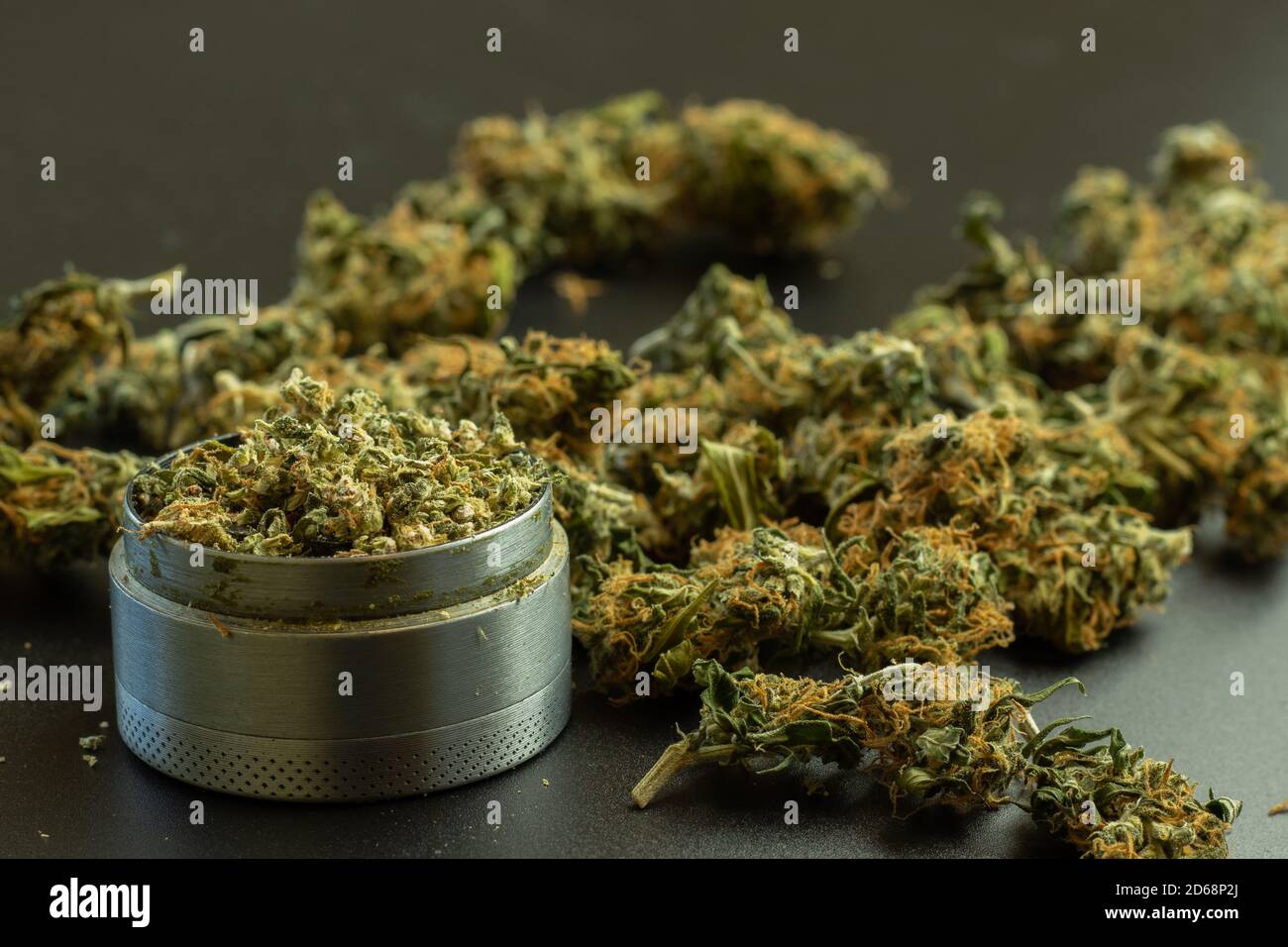 Marihuana Knospen auf dem Hintergrund mit Unschärfe, Grinder mit Cannabis, Kopierraum Stockfoto