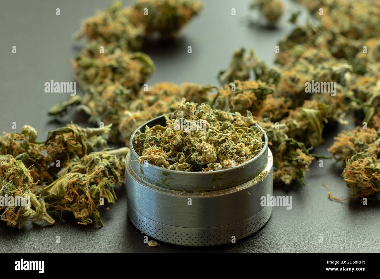 Grinder Nahaufnahme mit zerbröckeltem Marihuana und Cannabis Knospen in der Hintergrund Stockfoto