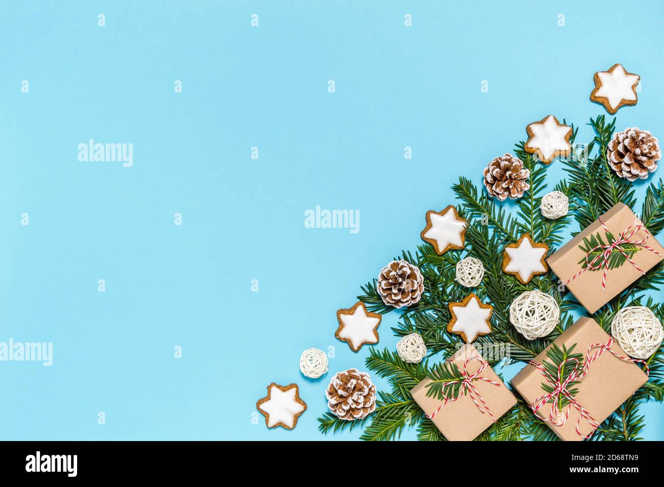 Kunststoff frei Weihnachten flach legen mit Bio-Urlaub Dekoration: Nadelbaum Äste, Tannenzapfen, Zimt Stern Cookies auf blauem Hintergrund Stockfoto