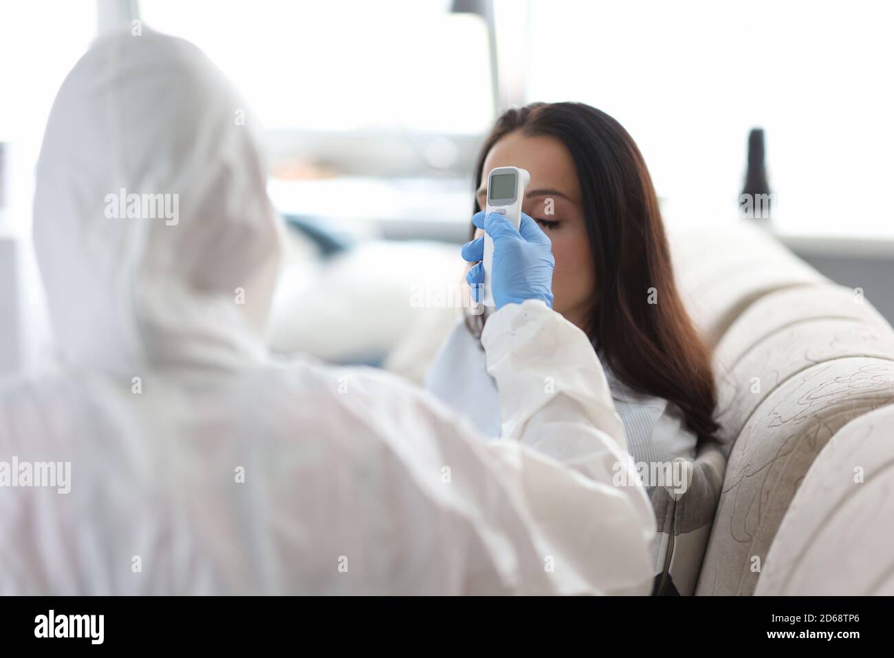 Der Arzt misst die Patiententemperatur mit einem berührungslosen Thermometer. Stockfoto