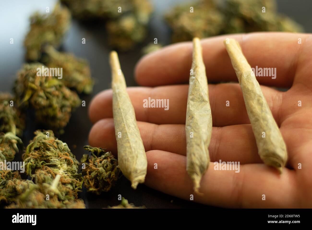 Gelenke mit Marihuana auf Handfläche Nahaufnahme und Cannabis auf Hintergrund Stockfoto