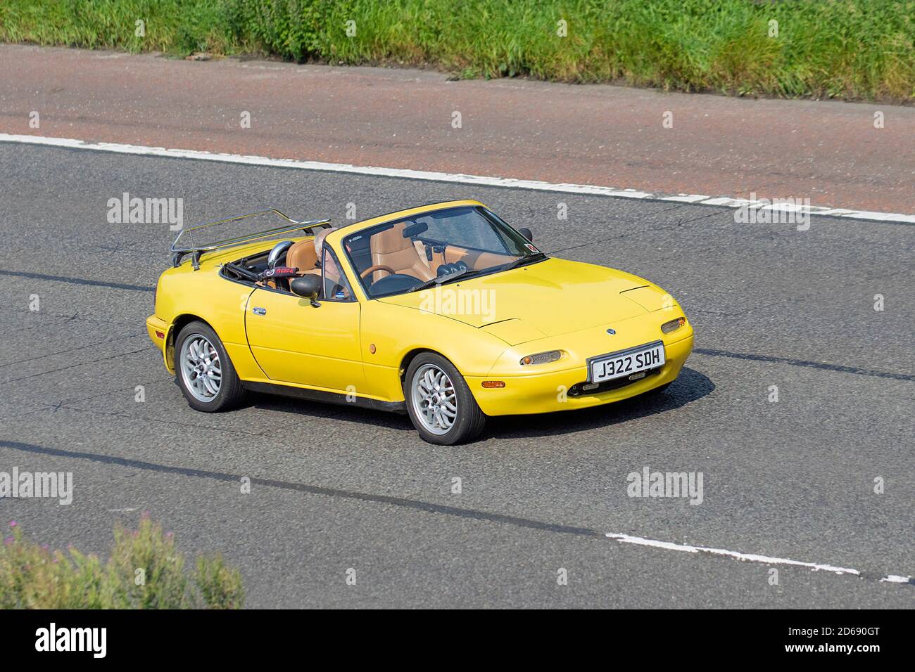 1991 90s Neunziger gelber Eunos MX5 MX-5 Fahrzeugverkehr, fahrende Fahrzeuge, Sportwagen, Fahrzeuge, die auf britischen Straßen fahren, Motoren, Autobahnfahrt auf dem britischen Straßennetz M6. Stockfoto