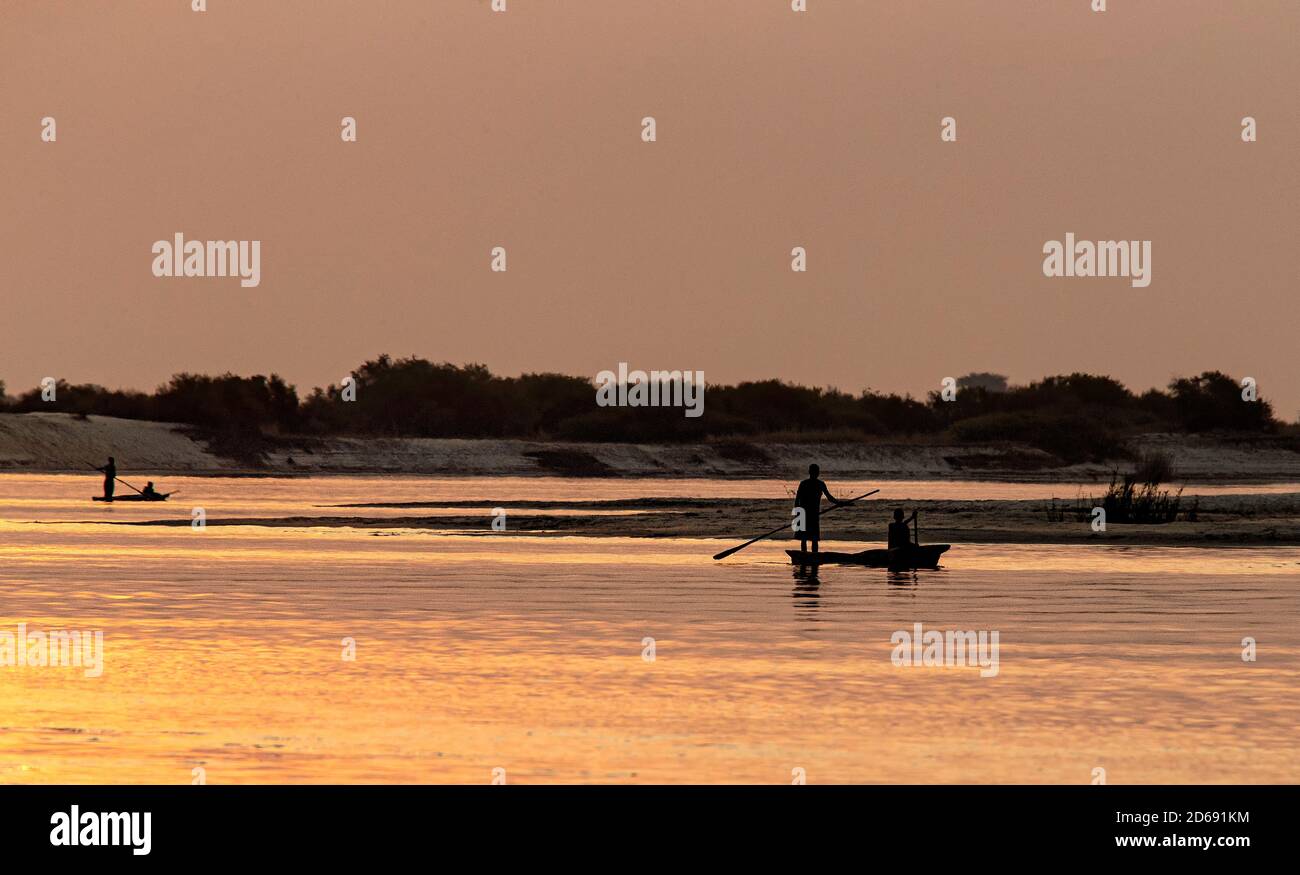 Mokoro oder ausgegrabenes Kanu, das bei Sonnenuntergang auf dem Zambezi zwischen Namibia und Sambia gemoldet wird. Stockfoto