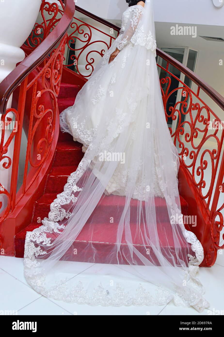 Brautkleid . Eine Braut steht eine rote Treppe. Stockfoto