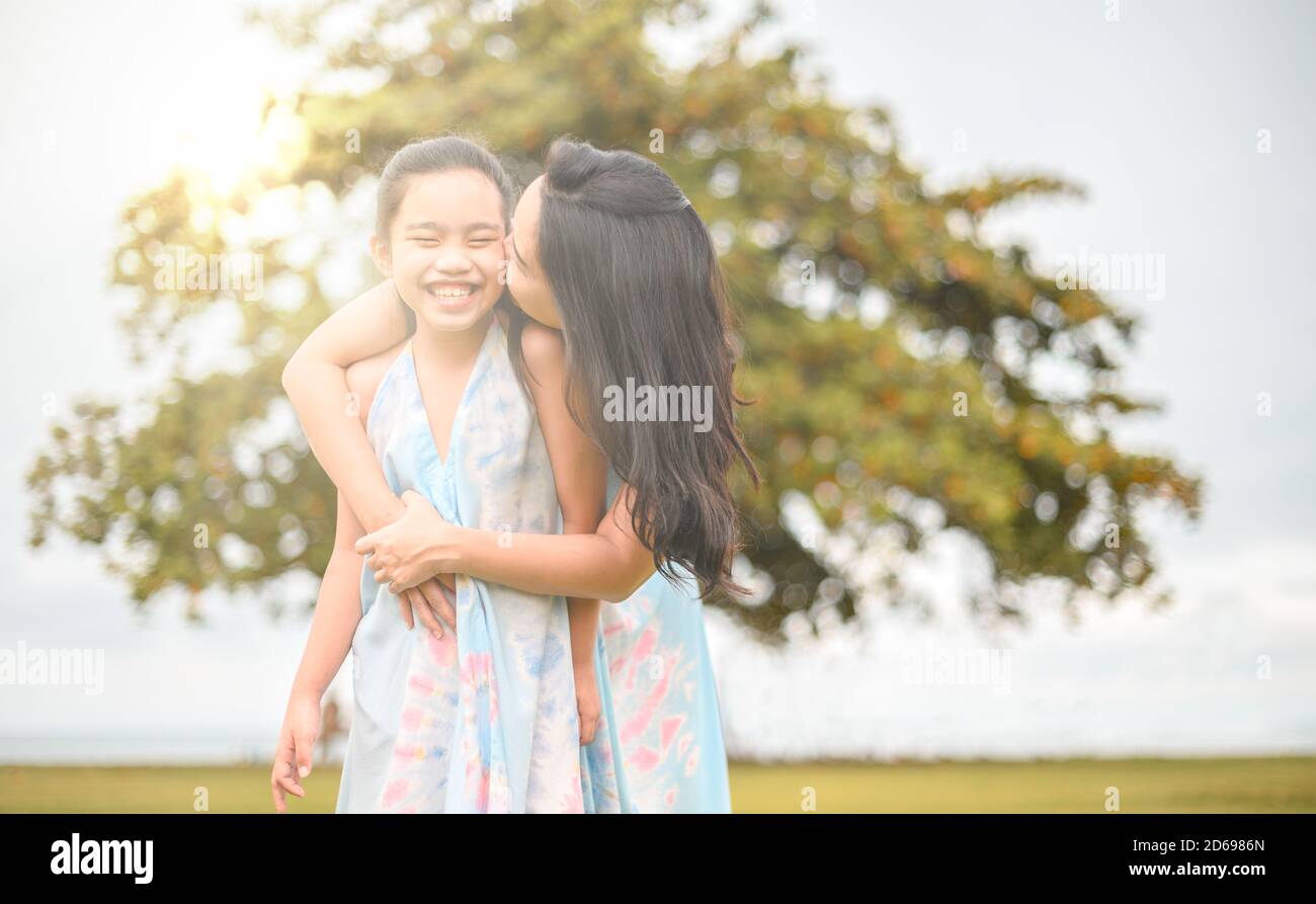 Glückliche Familie Mutter und Tochter auf Natur am Sonnenuntergang Stockfoto