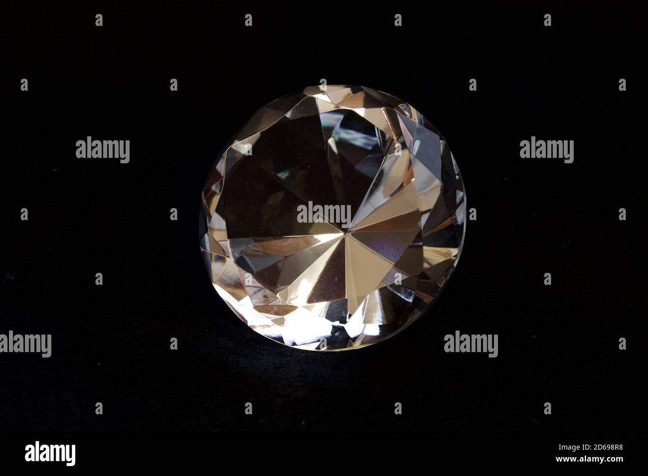 Diamantförmiger transparenter dekorativer Kristall mit schwarzem Hintergrund. Stockfoto