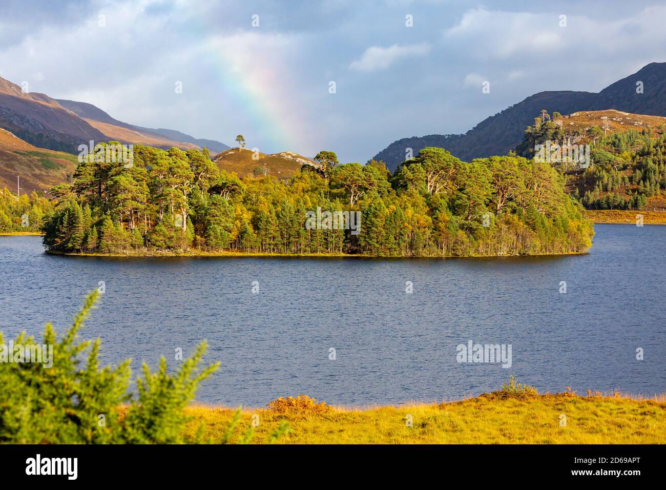 Loch A' Mhuillidh, Glen Strathfarrar in den Highlands von Schottland. Herbstfarben oder Herbstfarben mit einem Regenbogen im Hintergrund. Horizontal. Platz für Stockfoto