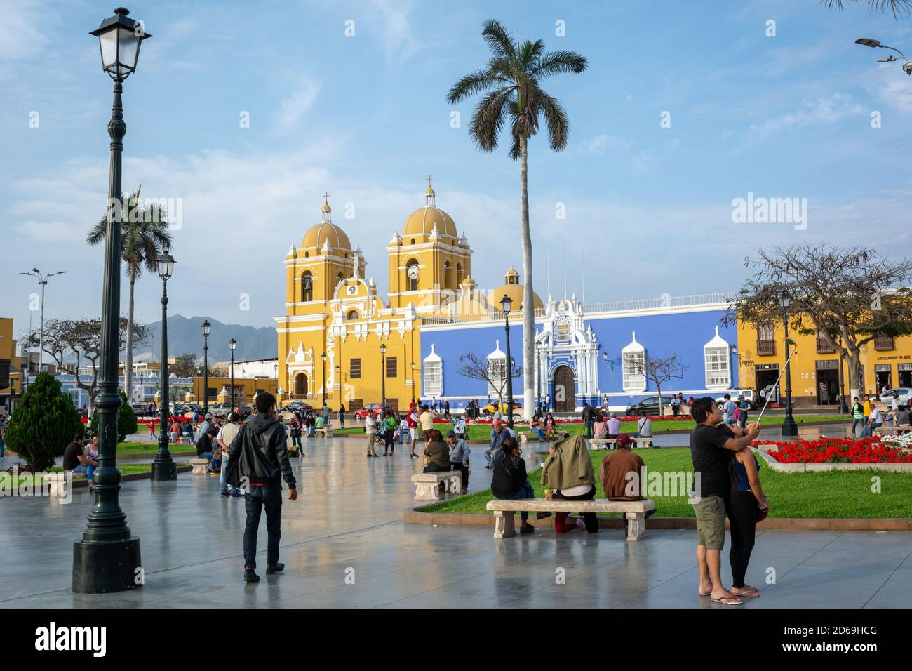 Der belebte koloniale Hauptplatz der Stadt Trujillo im Norden Perus mit der gelben Kathedrale von Santo Domingo und dem Bischofspalast in Blau. Stockfoto