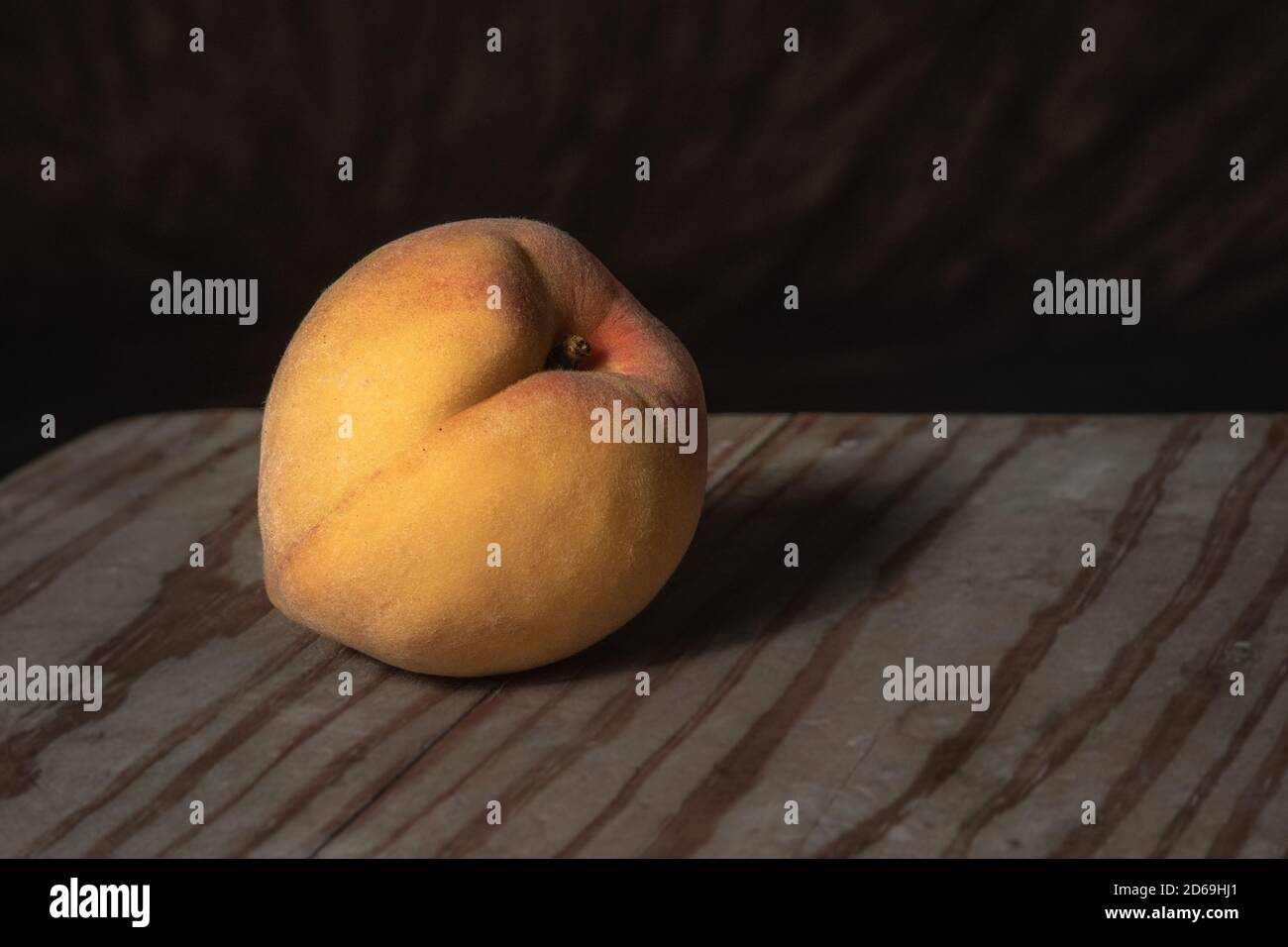 Stillleben low-key Schuss der Pfirsichfrucht auf roh Holzoberfläche Stockfoto