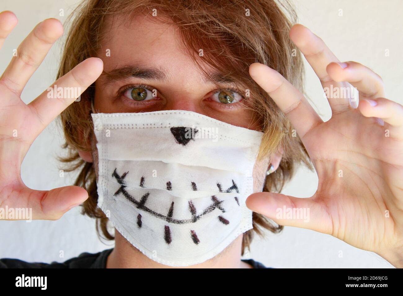 Junger Mann feiert Halloween mit medizinischer Gesichtsmaske wegen Covid-19 Pandemie Stockfoto
