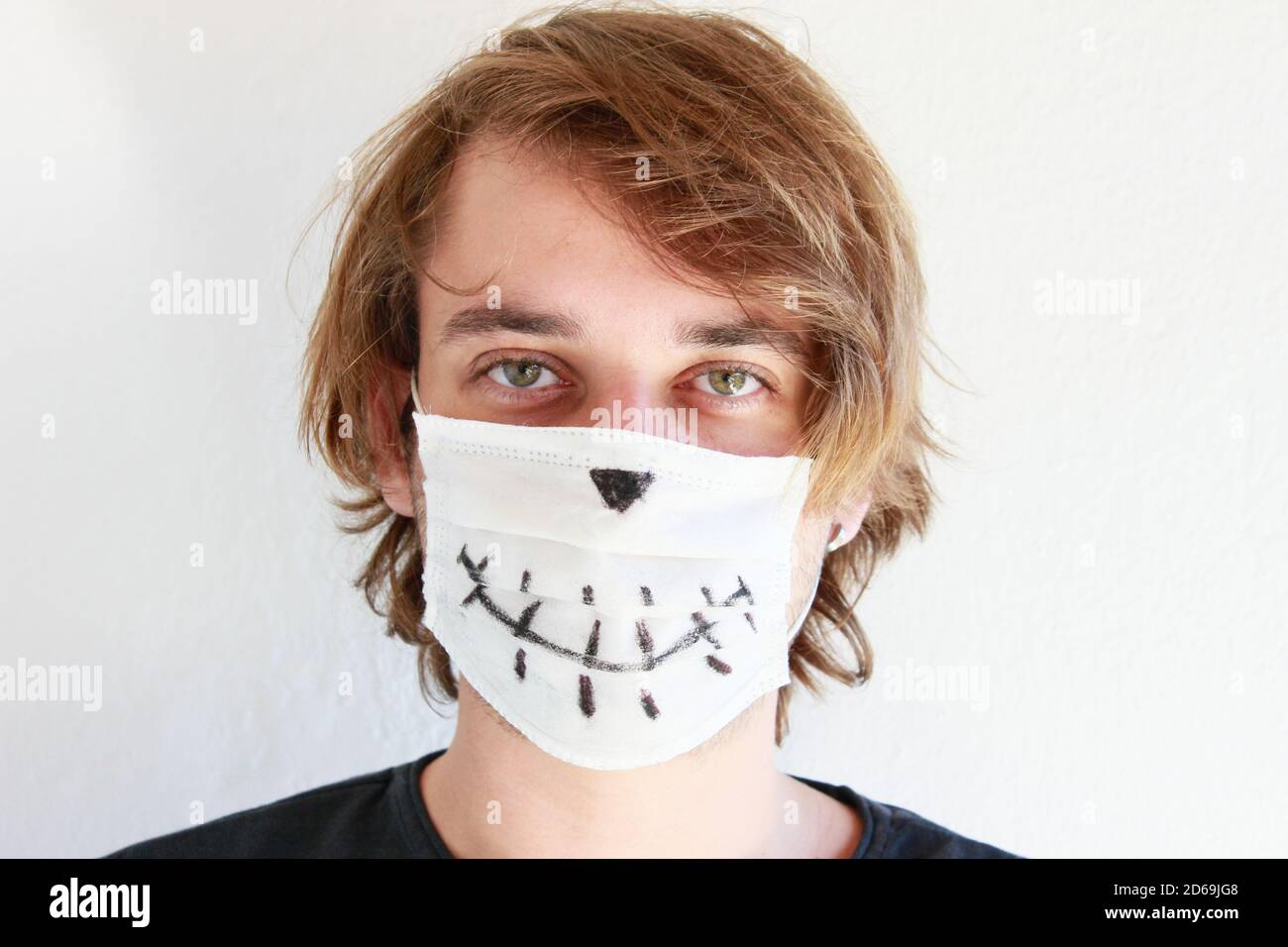 Junger Mann feiert Halloween mit medizinischer Gesichtsmaske wegen Covid-19 Pandemie Stockfoto