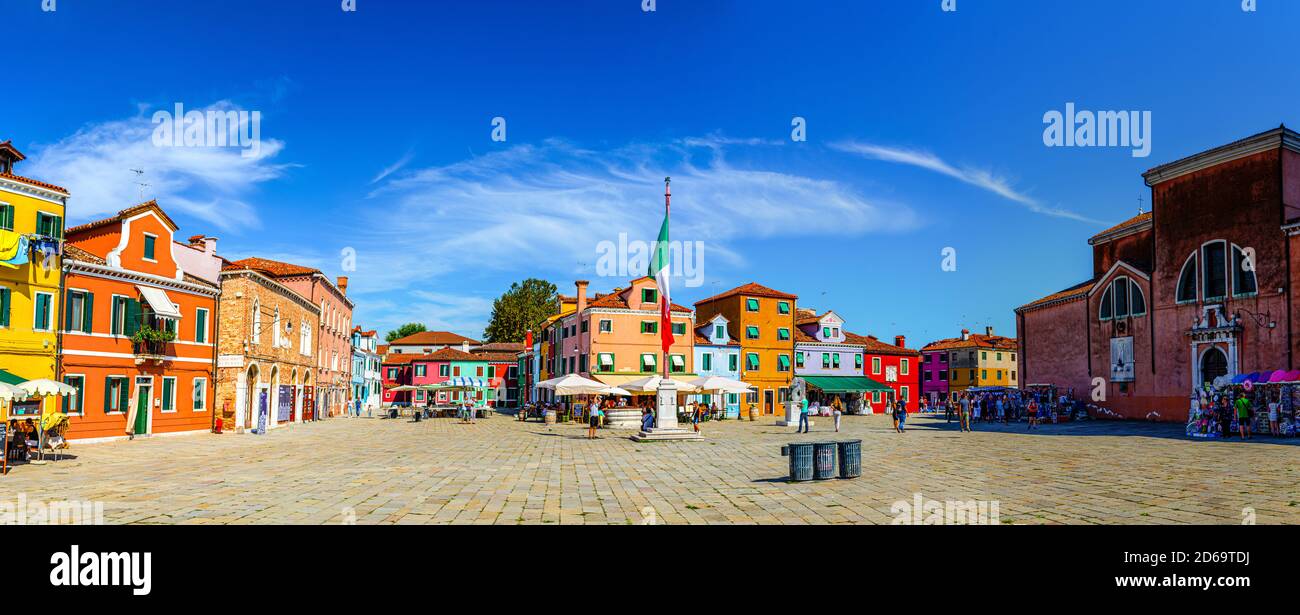 Burano, Italien, 14. September 2019: Zentraler Stadtplatz mit alten bunten bunten Gebäuden und italienischer Flagge, blauer Himmel im sonnigen Sommertag Hintergrund, Provinz Venedig, Region Venetien Stockfoto
