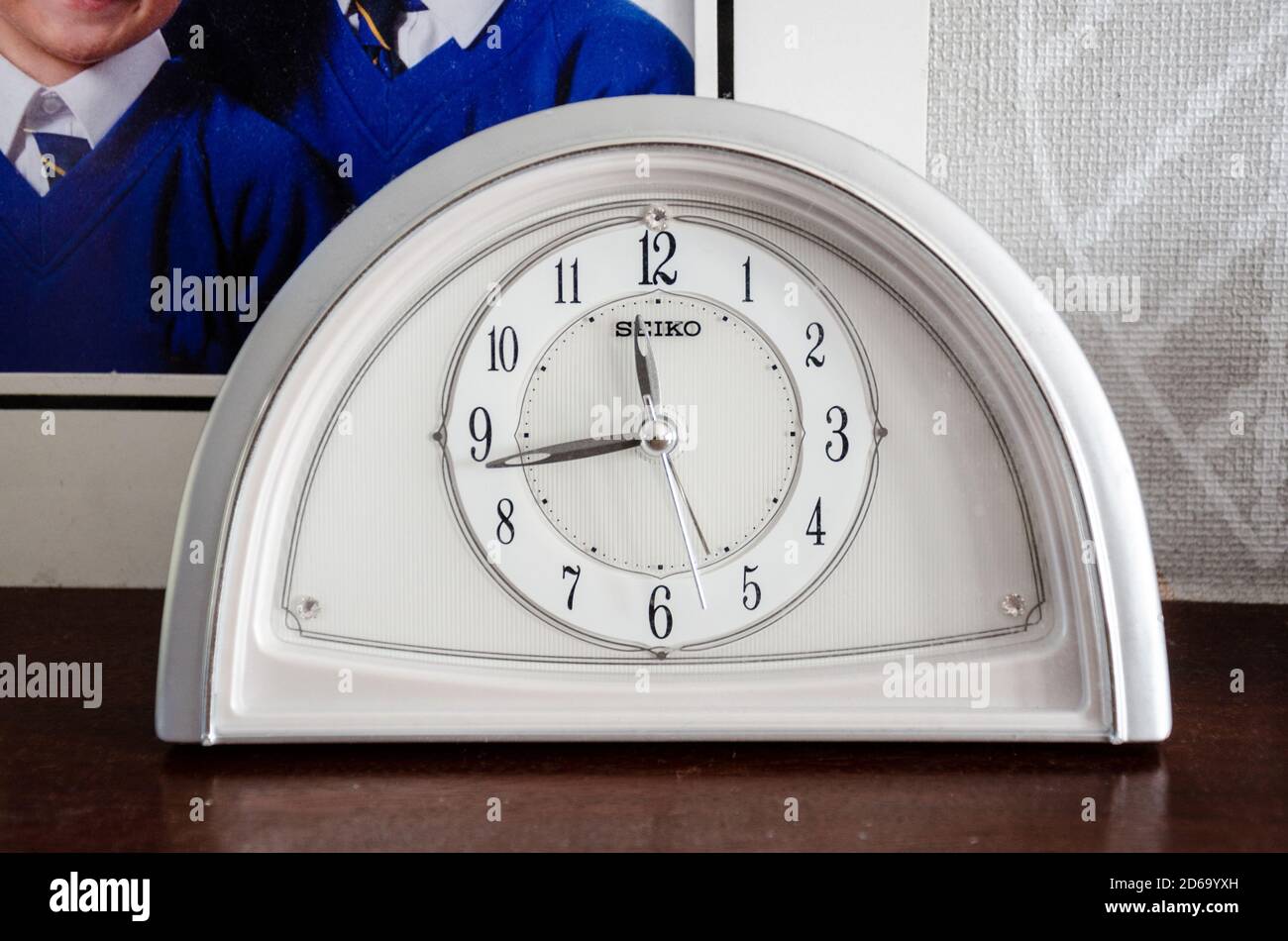 Nahaufnahme einer analogen Uhr auf einem Kaminsims in einem Familienhaus. Stockfoto