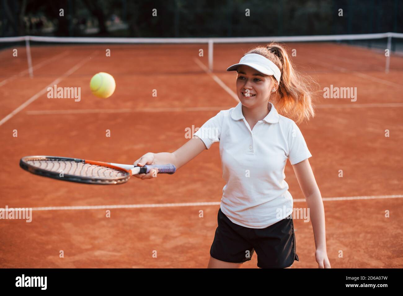 Junge Tennisspielerin in sportlicher Kleidung ist auf der platz im Freien Stockfoto