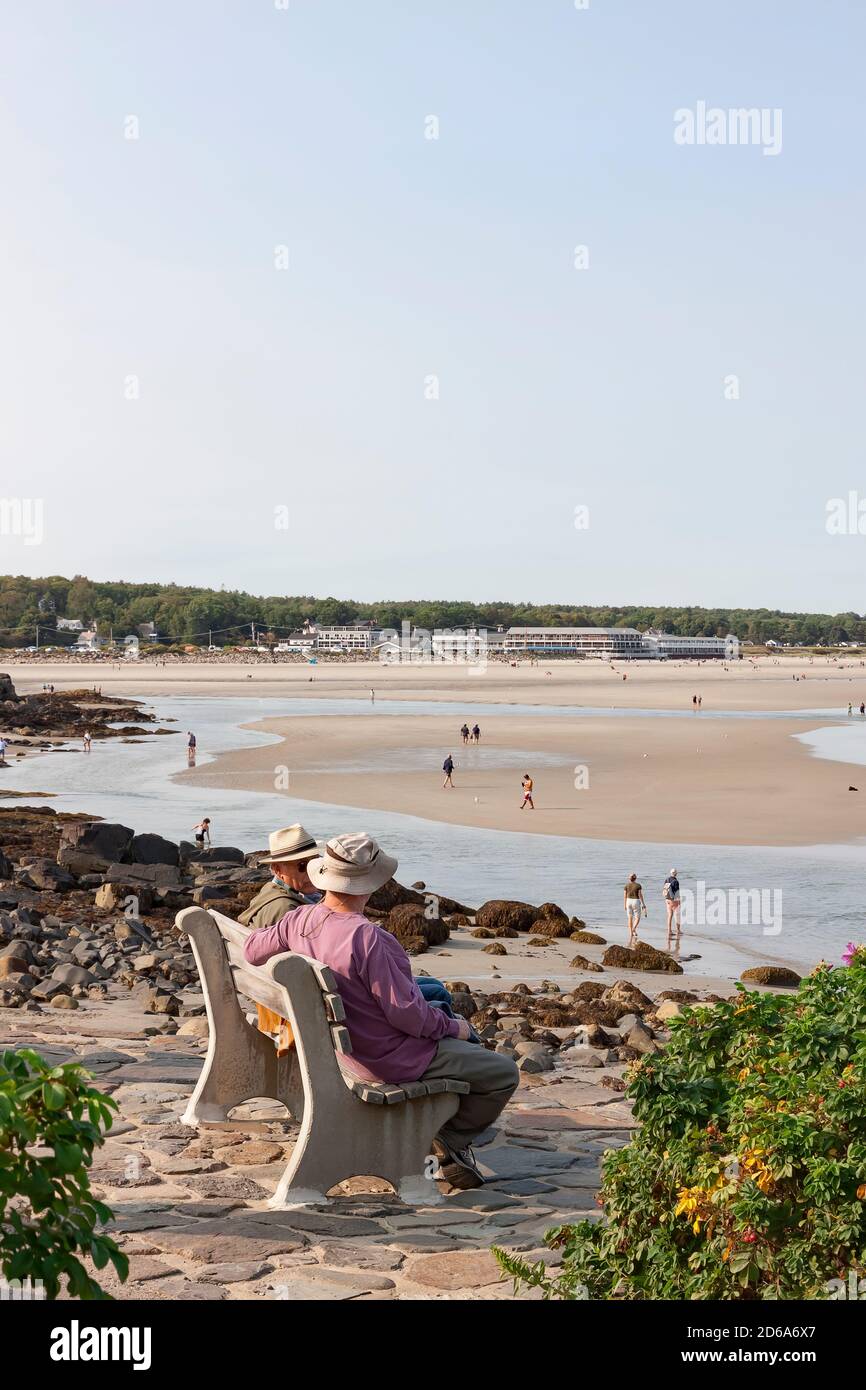 Männer sitzen und reden auf einer Bank mit Blick auf den Strand entlang marginal Way in Ogunquit, Maine, USA. Stockfoto
