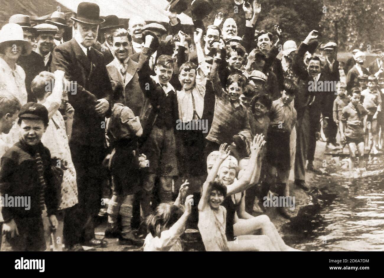 1930 Lord Lansbury ( Kommissar für Werke, George Lansbury) in Bowler hat die Einweihung des Hyde Park Serpentine Lido für gemischte Baden. Sie wurde zur Hälfte mit einer Spende von Major Colin Cooper (1892–1938) finanziert --- George Lansbury ( 1859–1940) war ein britischer Politiker und Sozialreformer und ein ehemaliger Führer der Labour Party (ursprünglich ein radikaler Liberaler), der gegen Ungerechtigkeit und Autorität kämpfte, die Interessen hatte. Er förderte die Abrüstung und half bei der Gründung der Tageszeitung Daily Herald und wurde deren Herausgeber. Stockfoto