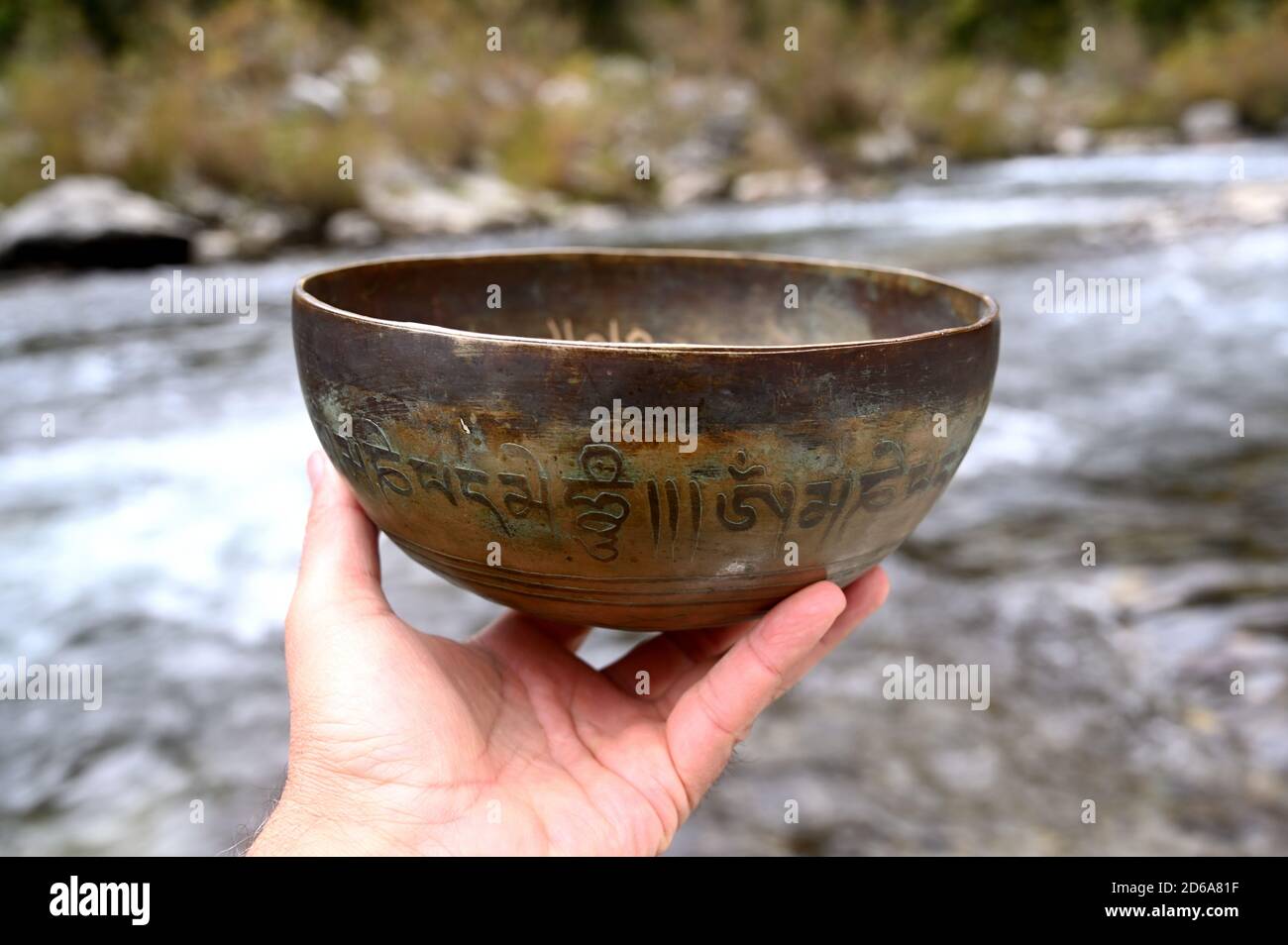 Ein Mann hält eine tibetische Kupferschale. Stockfoto