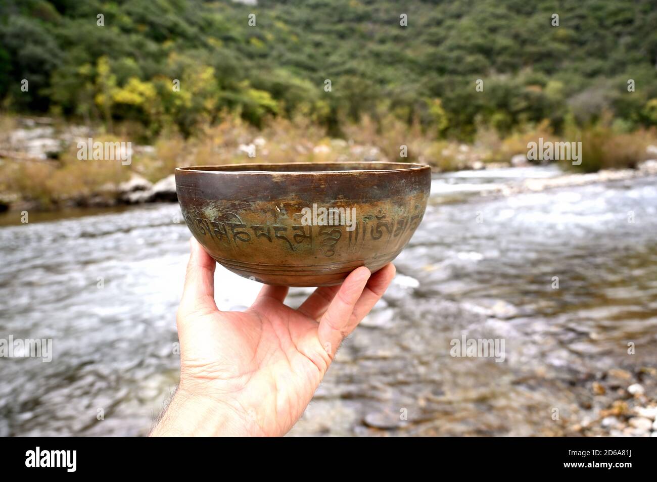 Ein Mann hält eine tibetische Kupferschale. Stockfoto