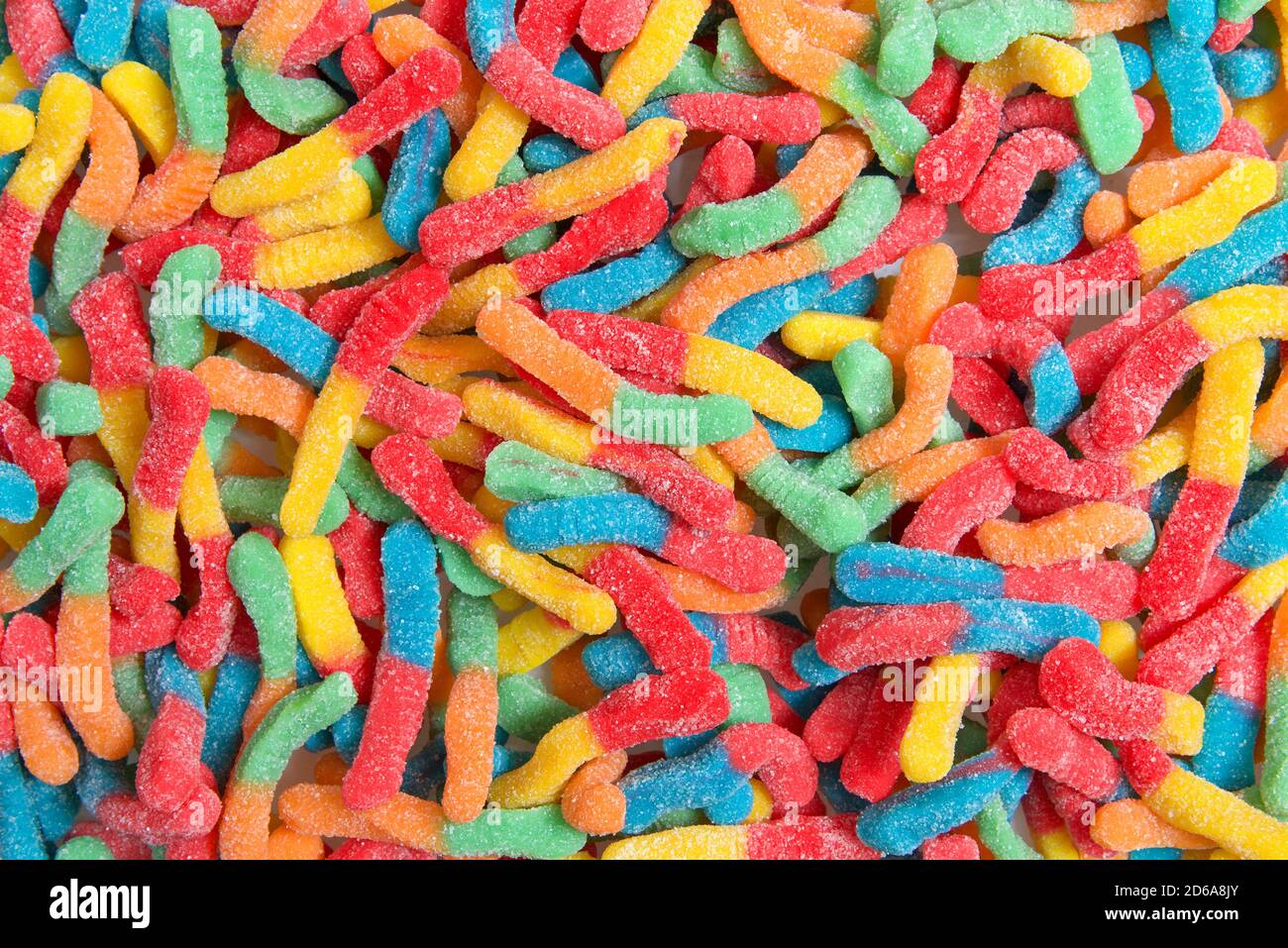 Saure Süßigkeiten Gummiwürmer Nahaufnahme Hintergrund. Mit granuliertem Zucker bedeckt. Flach liegend Draufsicht von oben. Stockfoto