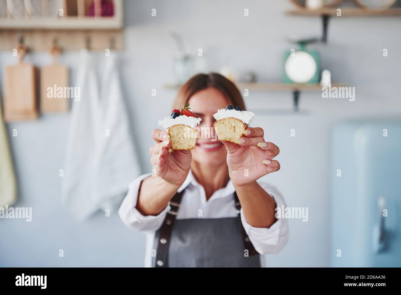 Frau steht drinnen in der Küche mit hausgemachtem Kuchen Stockfoto