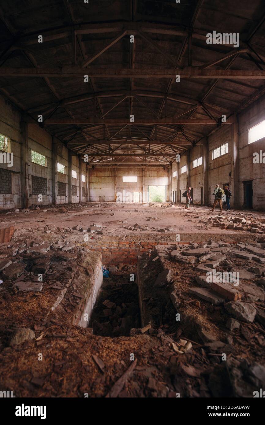 Verlassene Ruine Hangar mit hohem Dach am Tag. Im Inneren des verlassenen Gebäudes Stockfoto