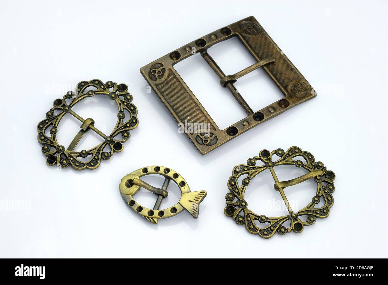 Dekorative Schnallen aus Metall. Bronze Dekorationen für Gürtel und Taschen Dekoration. Lockige Metallschnallen Draufsicht auf weißem Hintergrund. Zubehör für Stockfoto