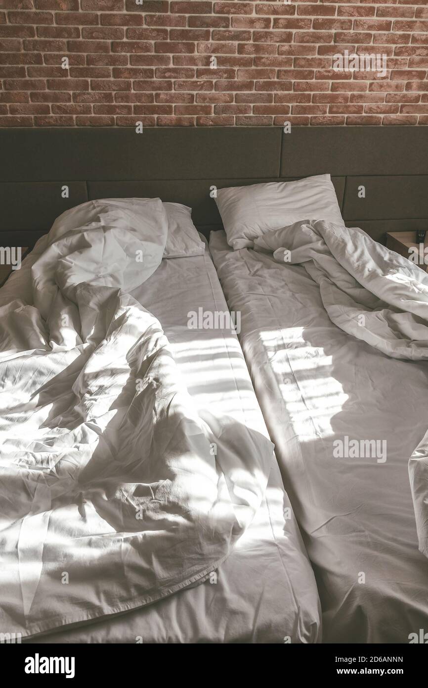 Schlafzimmer im Loft-Stil, ungefertigte Betten mit Decken Stockfoto