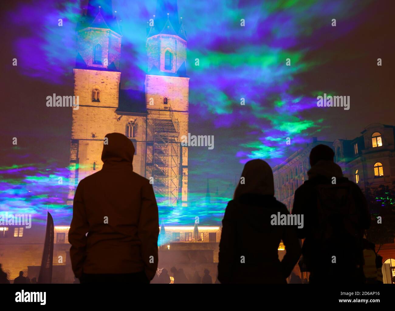 Halle, Deutschland. Oktober 2020. 15. Oktober 2020, Sachsen-Anhalt, Halle (Saale): Passanten sehen künstlich erzeugte Auroren auf dem Hallmarkt mit Laserstrahlen und Nebel. Die Lichtinstallation 'Borealis' des Schweizer Künstlers Dan Archer ist Teil des diesjährigen Silver Salt Science and Media Festivals. Unter dem Motto "Home Earth" findet sie vom 14. Bis 18. Oktober in Halle (Saale) statt. Foto: Jan Woitas/dpa-Zentralbild/dpa Quelle: dpa picture Alliance/Alamy Live News Stockfoto